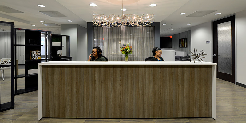 Two women are sat behind a Regus reception desk